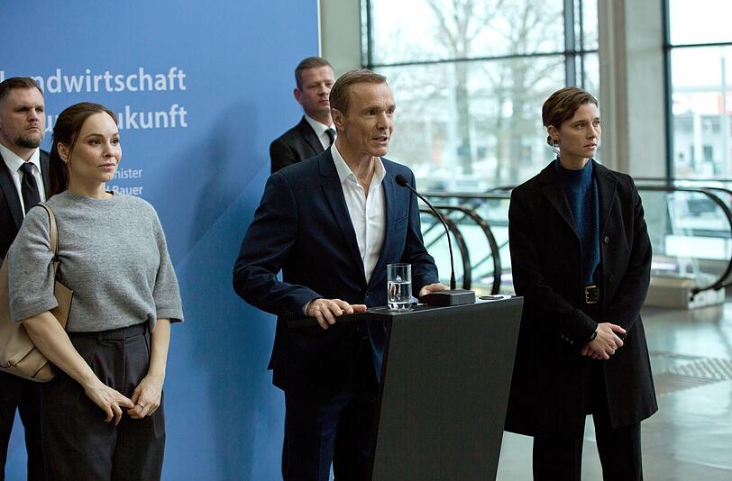 Wirtschafts- und Umweltminister Bauer (Hannes Jaenicke, zweiter von rechts) wird bei einer Rede angegriffen, Personensch&uuml;tzerin Helen Schilling (Svenja Jung, rechts) kann nicht viel tun.