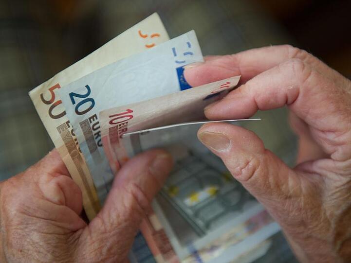 Eine Frau zählt Geld. Foto: Marijan Murat/dpa/Archivbild