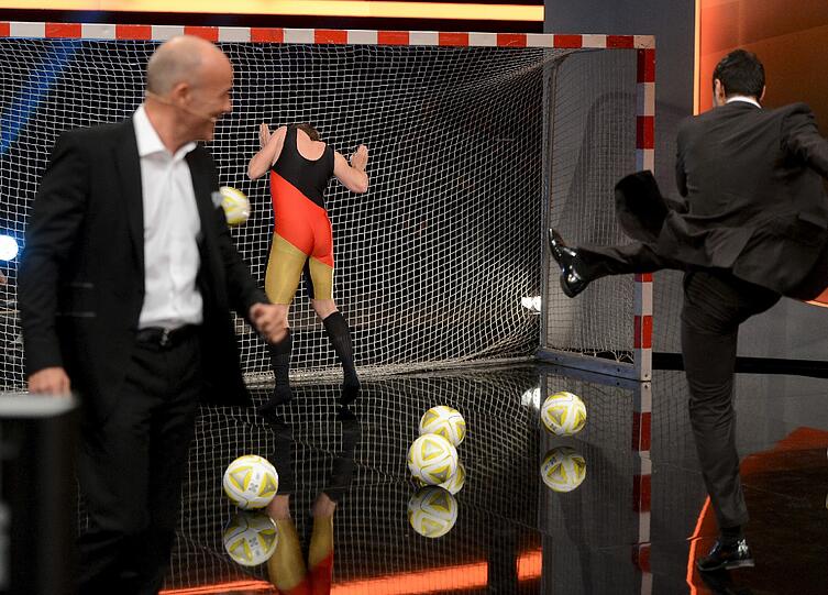 Er musste sich einen hautengen Overall anziehen und in ein Fußballtor stellen. Dann schossen Zuschauer Bälle auf ihn.
