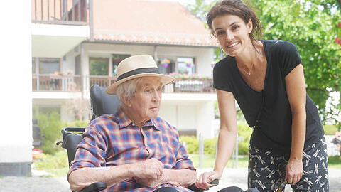 Steffi Schäflein-Thompson aus Grünwald holt ihren Vater John (89) im Pflegeheim ab, dreht mit ihm eine kleine Runde. Er sitzt im Rollstuhl.