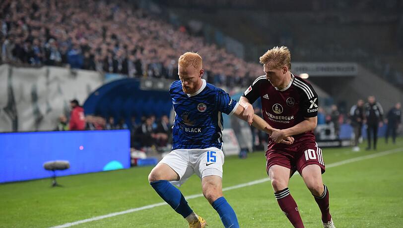 Rostocks Nils Fröling (l) verteidigt den Ball gegen Nürnbergs Mats Möller Daehli.
