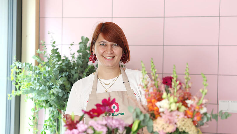 Blumenhändlerin Elena Straßl in ihrem bunten Standl auf dem Elisabethmarkt. Ihr Stand steht unter dem Motto "Blumen für alle".