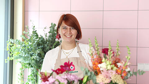 Blumenhändlerin Elena Straßl in ihrem bunten Standl auf dem Elisabethmarkt. Ihr Stand steht unter dem Motto "Blumen für alle".