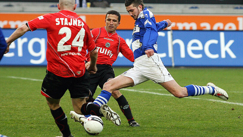 MSV Duisburg (2007 -2008): Hier holt Mölders (re.) am 22. März 2008 gegen Sergio Pinto (Hannover, Mi.) zum Schuss aus. Doch: Nicht nur gegen die Hannoveraner trifft er nicht. In seiner ersten Bundesliga-Saison bleibt der damals Anfang Zwanzigjährige ohne eigenes Tor - und der Meidericher SV steigt als Tabellenletzter ab.