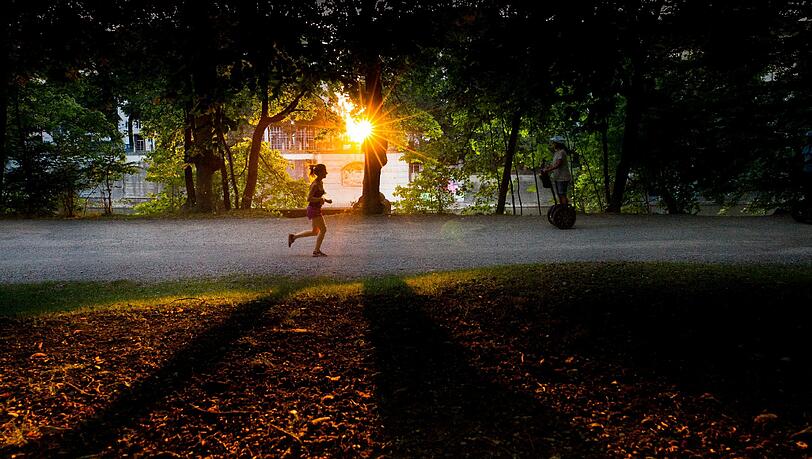 Spätsommer in München: Die Sonne blinzelt durch die angebräunten Blätter der Bäume am Isarufer. Für Jogger und Spaziergänger ein schönes Naturschauspiel. Spätsommer in München: Die Sonne blinzelt durch die angebräunten Blätter der Bäume am Isarufer. Für Jogger und Spaziergänger ein schönes Naturschauspiel.