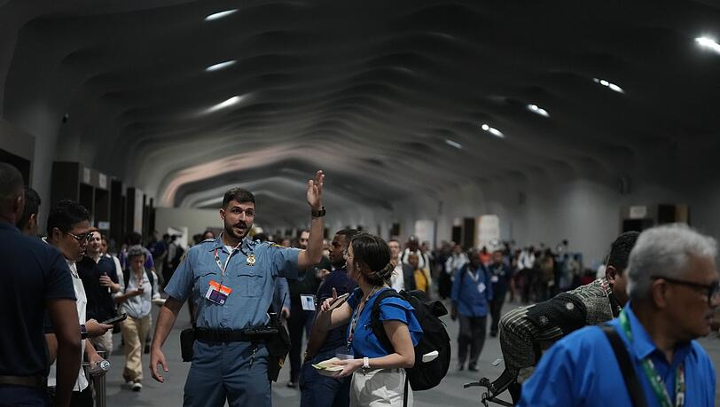 Menschen verlassen das Gelände der Weltklimakonferenz COP 30 wegen eines Feuers.