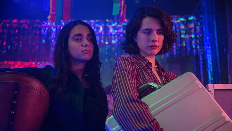 Die langsam auftauende Prüde und die sexuell Unbekümmerte: Geraldine Viswanathan und Margaret Qualley mit dem Dildokoffer in Ethan Coens Film "Drive-Away Dolls". Die langsam auftauende Prüde und die sexuell Unbekümmerte: Geraldine Viswanathan und Margaret Qualley mit dem Dildokoffer in Ethan Coens Film "Drive-Away Dolls".