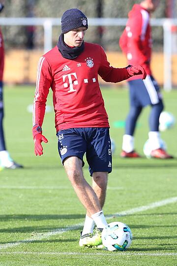 Auch Thomas Müller versucht sich warm eingepackt an ein paar Kunststücken mit dem Ball.