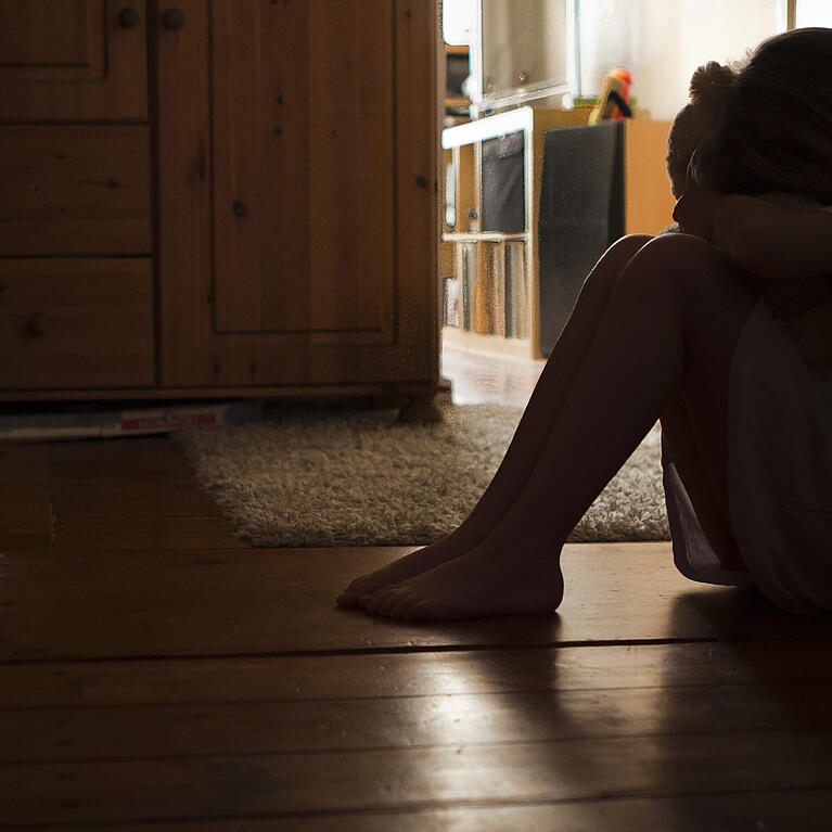 Ein Mädchen sitzt verzweifelt am Boden (Symbolbild).