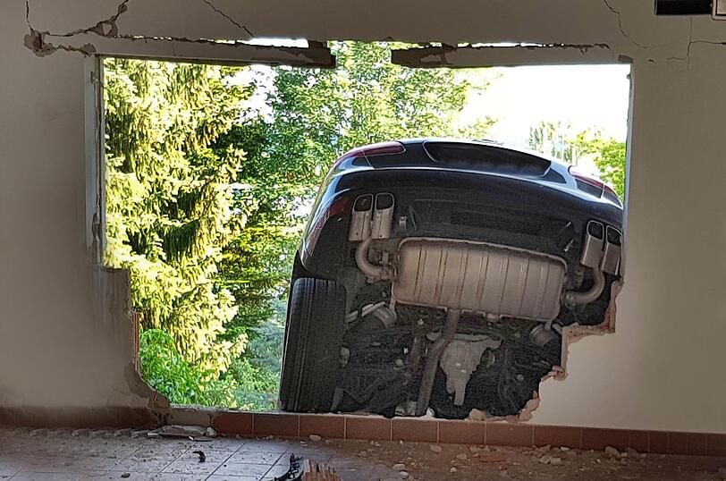 Ein Mann hat mit seinem Porsche die Garagenwand durchbrochen und ist im Garten gelandet. Die Bilder vom Einsatz.