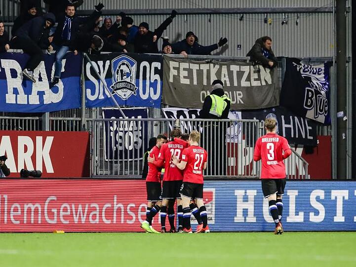 Die Bielefelder feiern vor ihren Fans den Siegtreffer zum Auswärtssieg in Kiel.