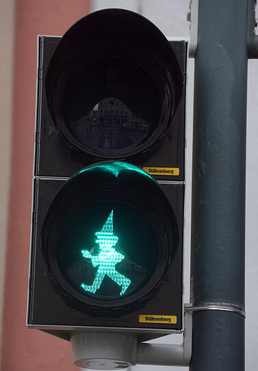 An einer Ampel leuchtet in Augsburg die Silhouette des Kasperl. Nahe der Augsburger Puppenkiste gibt die Marionette den Weg frei.