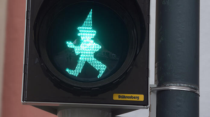 An einer Ampel leuchtet in Augsburg die Silhouette des Kasperl. Nahe der Augsburger Puppenkiste gibt die Marionette den Weg frei.