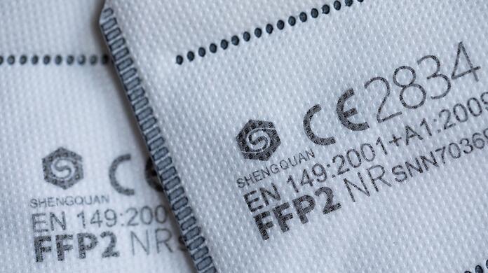 FFP2-Masken mit CE-Zertifizierung liegen auf einem Tisch.