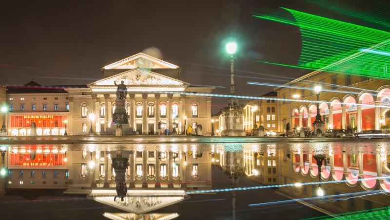 Die bayerische Staatsoper spiegelt sich in einer Pfütze auf der Residenzstraße. Foto: Peter Kneffel/dpa/Archivbild Die bayerische Staatsoper spiegelt sich in einer Pfütze auf der Residenzstraße. Foto: Peter Kneffel/dpa/Archivbild