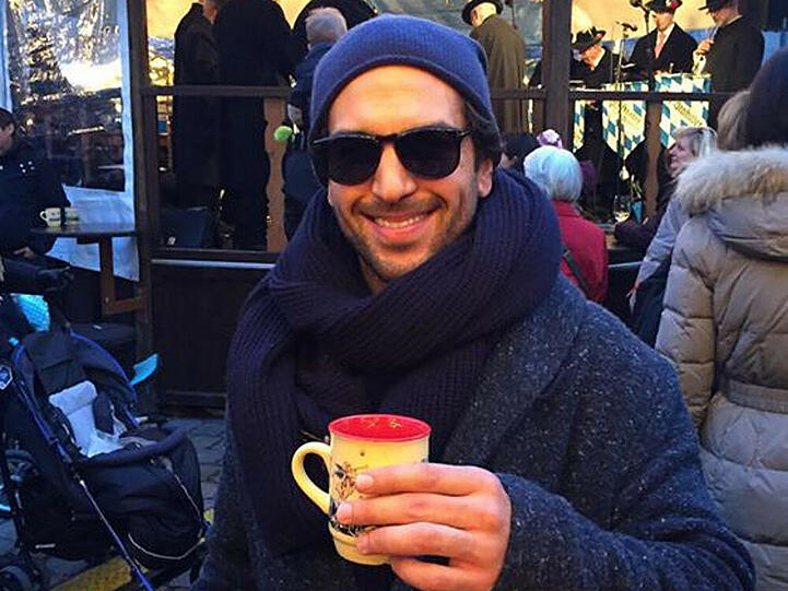 Mit Sonnebrille auf der Nase schlendert Elyas M'Barek über den Weihnachtsmarkt in München