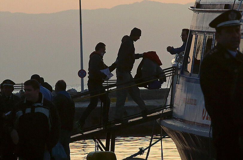 Illegale Migranten besteigen ein Boot im Hafen der griechischen Insel Lesbos. Das erste Schiff mit 138 Migranten an Bord lief anschließend ins türkische Dikili aus. Foto: Orestis Panagiotou