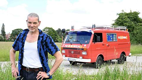 Stolzer Besitzer seines "Fernweh"-Mobils: Schauspieler Götz Otto vor seinem zum Wohnmobil umgebauten alten Feuerwehrauto.