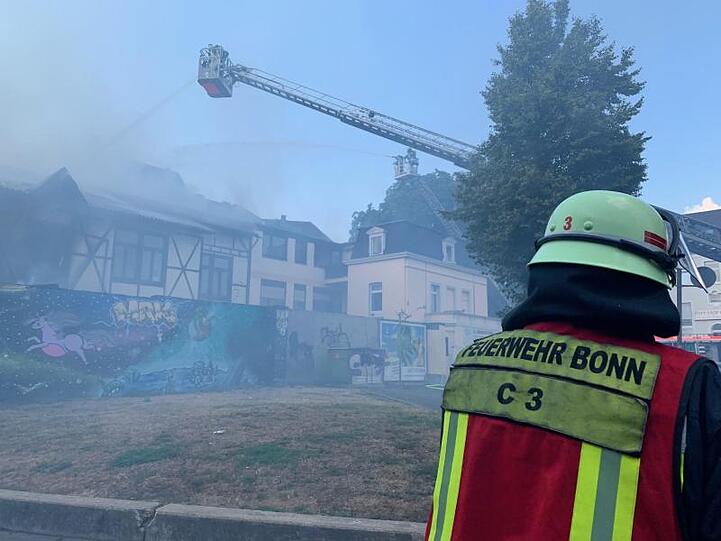 Über eine Drehleiter bekämpft die Bonner Feuerwehr den Brand in der Schreinerei und dem dazugehörigen Wohnhaus.