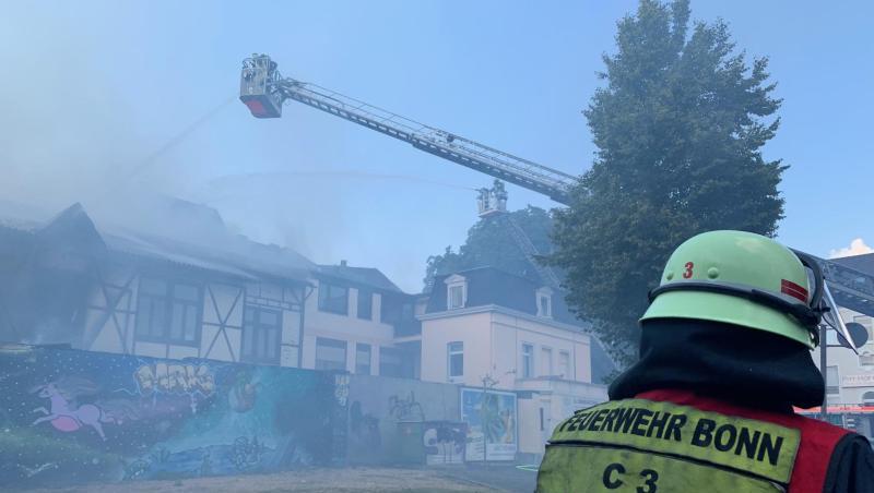 Über eine Drehleiter bekämpft die Bonner Feuerwehr den Brand in der Schreinerei und dem dazugehörigen Wohnhaus.