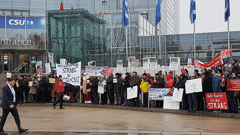 Vor der Halle demonstrieren zahlreiche Menschen gegen die Straßenausbaubeitragssatzung (Strabs).