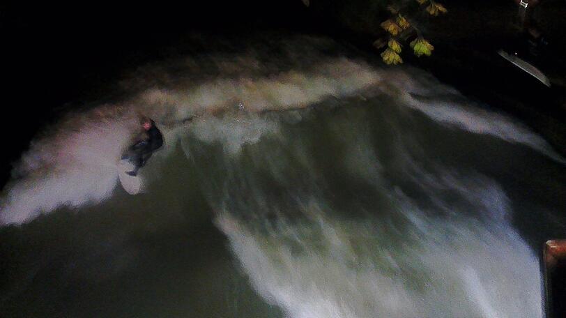 Dunkelheit kann sie nicht aufhalten: Am Eisbach wird einfach bei Flutlicht gesurft.