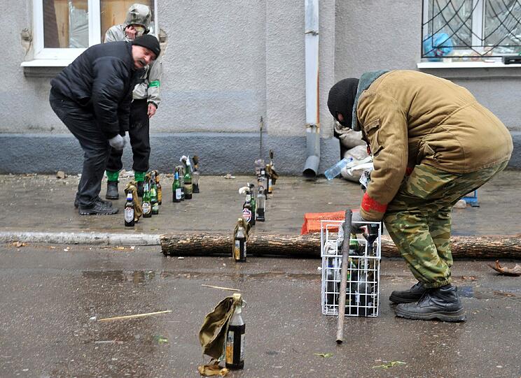 Bereit für den Einsatz gegen ukrainische Sicherheitskräfte: pro-russische Kämpfer sichern ihre Barrikaden bei Slawjansk mit Molotow-Cocktails. Foto: ANATOLIY STEPANOV/AFP
