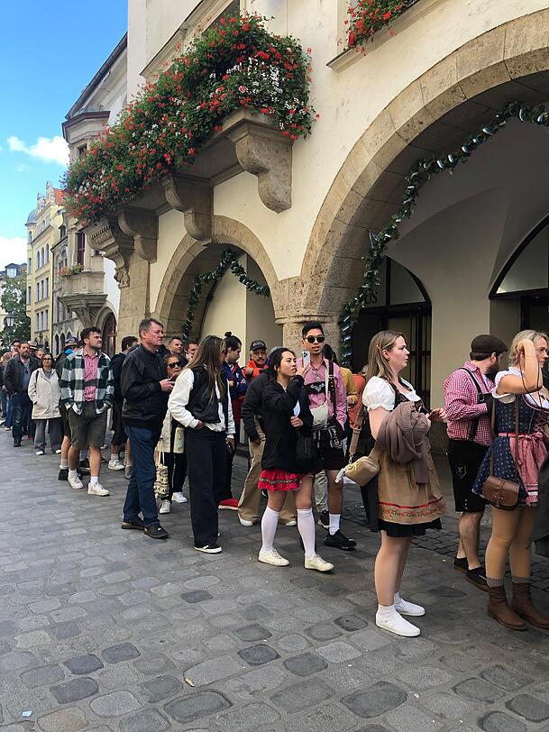 Vor dem Hofbräuhaus in der Münchner Innenstadt warten Wiesn-Besucher geduldig – Plan B nach der Sperrung des Festgeländes.