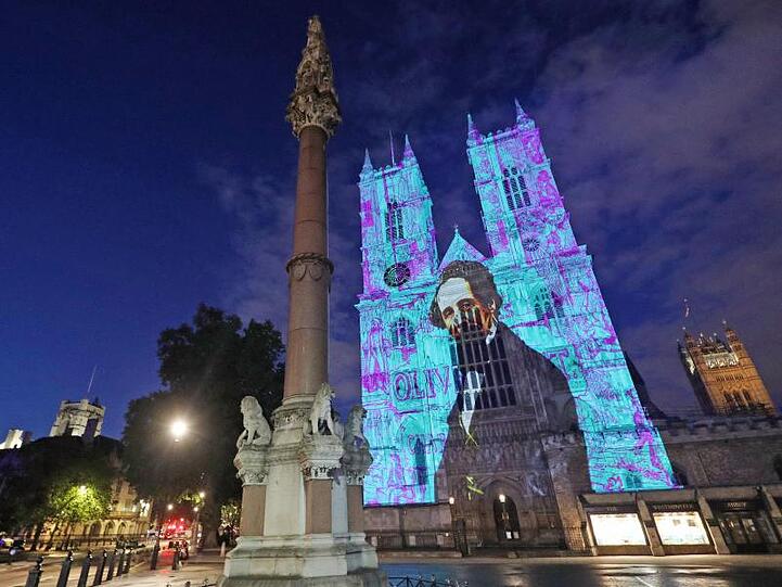 Charles Dickens wird auf die Westtürme der Westminster Abbey projiziert.