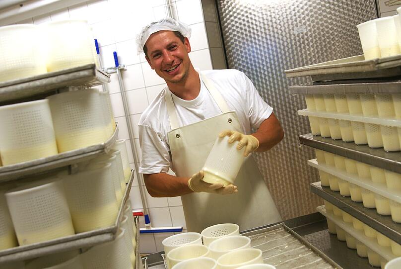 Der Mann, der den Käse wendet: Mitarbeiter Ladislav Chano dreht den Camembert im Becher um. In dem kleinen Betrieb geschieht vieles per Hand.