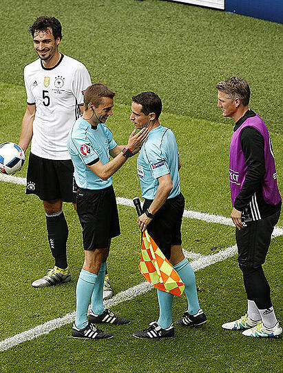 Schiedsrichter Clement Turpin kümmert sich um seinen Assistenten Fréderic Cano. Links Mats Hummels, rechts Bastian Schweinsteiger.