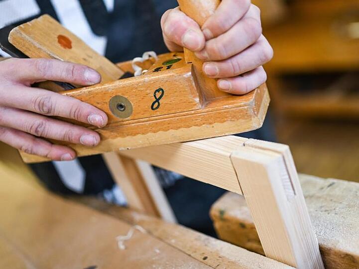 Ein Auszubildender im Schreiner-Handwerk arbeitet an einem Werkstück. Foto: Felix Kästle/dpa/Archivbild