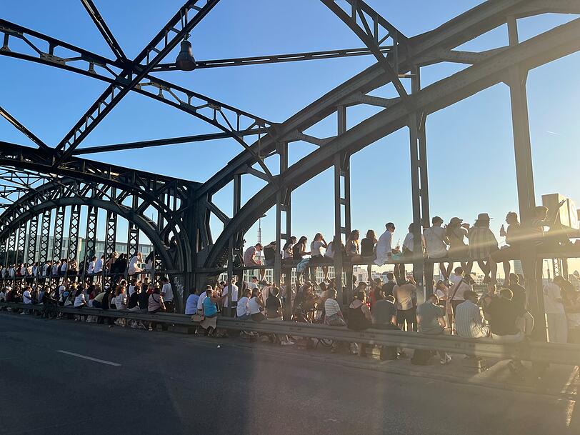 Hunderte, meist junge, Menschen verfolgen die Sonnenfinsternis von der Hackerbr&uuml;cke aus.