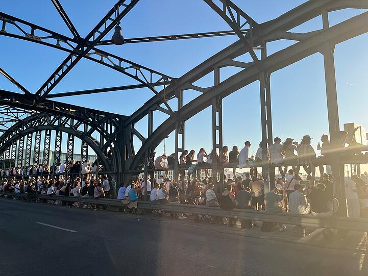 Hunderte, meist junge, Menschen verfolgen die Sonnenfinsternis von der Hackerbr&uuml;cke aus.