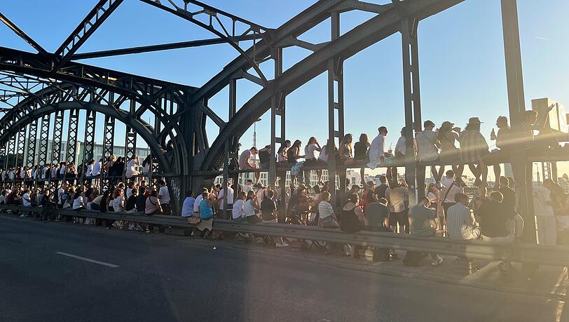 Hunderte, meist junge, Menschen verfolgen die Sonnenfinsternis von der Hackerbrücke aus. Hunderte, meist junge, Menschen verfolgen die Sonnenfinsternis von der Hackerbrücke aus.