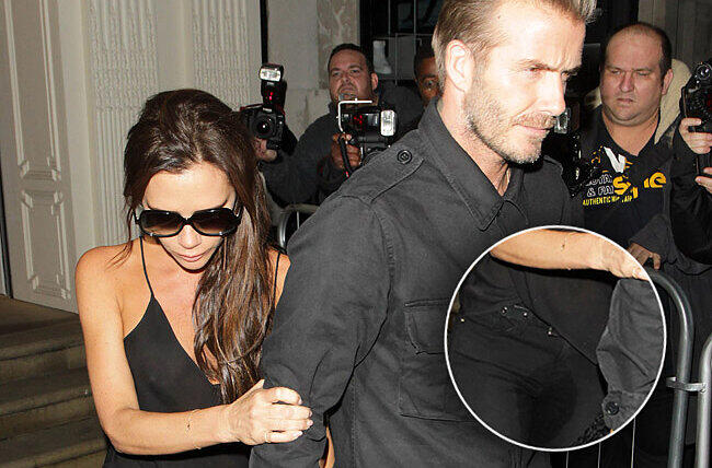 Victoria Beckham versteckt sich hinter ihrem Mann David, um das Malheur zu kaschieren. Leider erfolglos.