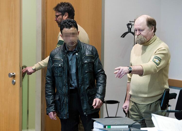 Der 37-Jährige Regayit K. aus München nimmt am 18.03.2013 in Augsburg seinen Platz auf der Anklagebank im Verhandlungsraum des Landgerichts Augsburg ein.