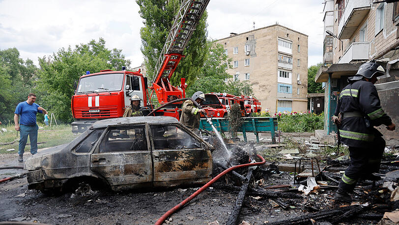 Donezk: Feuerwehrleute löschen ein Wohnhaus und brennende Autos nach einem Beschuss im Osten der Ukraine. Donezk: Feuerwehrleute löschen ein Wohnhaus und brennende Autos nach einem Beschuss im Osten der Ukraine.