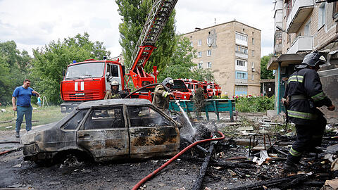 Donezk: Feuerwehrleute löschen ein Wohnhaus und brennende Autos nach einem Beschuss im Osten der Ukraine.