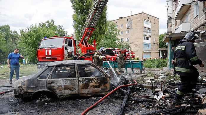 Donezk: Feuerwehrleute löschen ein Wohnhaus und brennende Autos nach einem Beschuss im Osten der Ukraine.