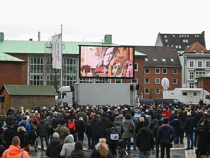 Die Trauerfeier im Michel wird auf einer Leinwand übertragen.