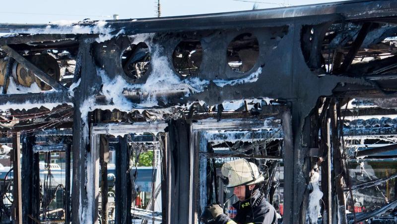 Ein Feuerwehrmann kontrolliert mit einer Wärmebildkamera ausgebrannte Busse auf einem Betriebshof im Stadtteil Wandsbek. Ein Feuerwehrmann kontrolliert mit einer Wärmebildkamera ausgebrannte Busse auf einem Betriebshof im Stadtteil Wandsbek.