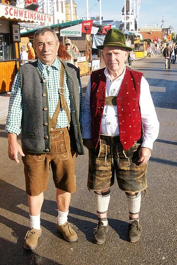 Von links: Hans Schaberer (82) aus Gilching und Adam Alfred (82) aus Forstenried, beide ehemalige Landwirte:
"Wir gehen erst aufs ZLF und dann auf die Wiesn. Zwei oder drei Mal das muss schon sein. Früher hat man es sich nicht leisten können, heut freut's einen umso mehr. Wir gehen einfach dort hin, wo wir einen Platz finden." - "Ich bin mit 5 Jahren schon hier rausgegangen," sagt Adam. Die Tracht gehört dazu, da sind sich beide einig.