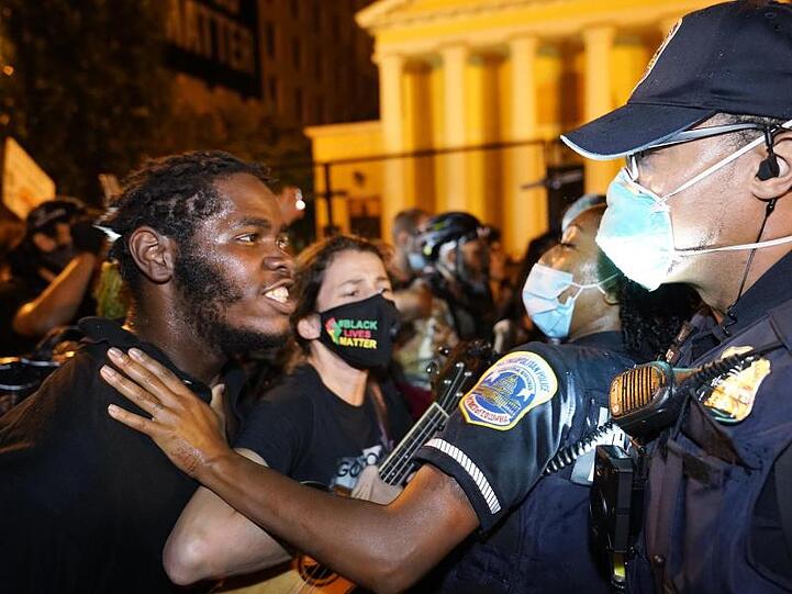 Ein Demonstranten spricht mit einer Polizistin während eines Protests gegen US-Präsident Trump auf dem "Black Lives Matter"-Plaza.