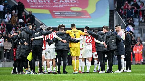 Die Spieler von Augsburg stehen nach dem Spiel zusammen im Kreis.