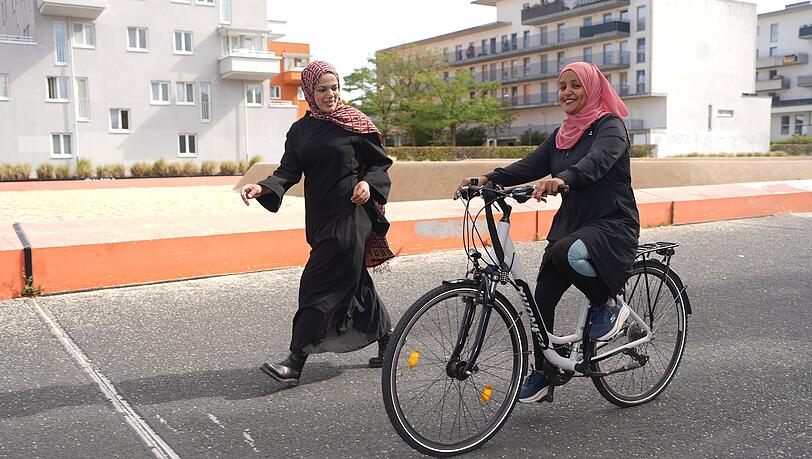 Gute &Uuml;bungsstrecke: Radl-Trainerin Dua'a und Radl-Sch&uuml;lerin Jemila auf dem Quartiersplatz in M&uuml;nchen.