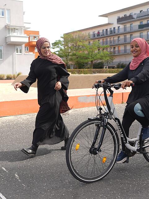 Gute &Uuml;bungsstrecke: Radl-Trainerin Dua'a und Radl-Sch&uuml;lerin Jemila auf dem Quartiersplatz in M&uuml;nchen.