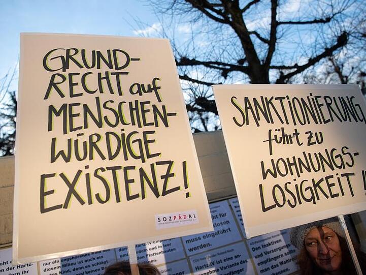 Demonstranten stehen während der Verhandlung über die Rechtmäßigkeit von Hartz-IV-Sanktionen vor dem Bundesverfassungsgericht.