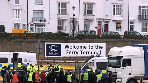 Die Polizei hält Fahrer zurück, die versuchen, in den Hafen von Dover zu laufen. Am englischen Hafen Dover ist es zwischen wartenden Lkw-Fahrern und der Polizei zu Schubsereien und Handgemenge gekommen.