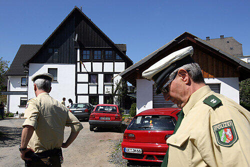 Polizisten stehen vor dem Haus in Wenden, in dem drei Babyleichen gefunden wurden.